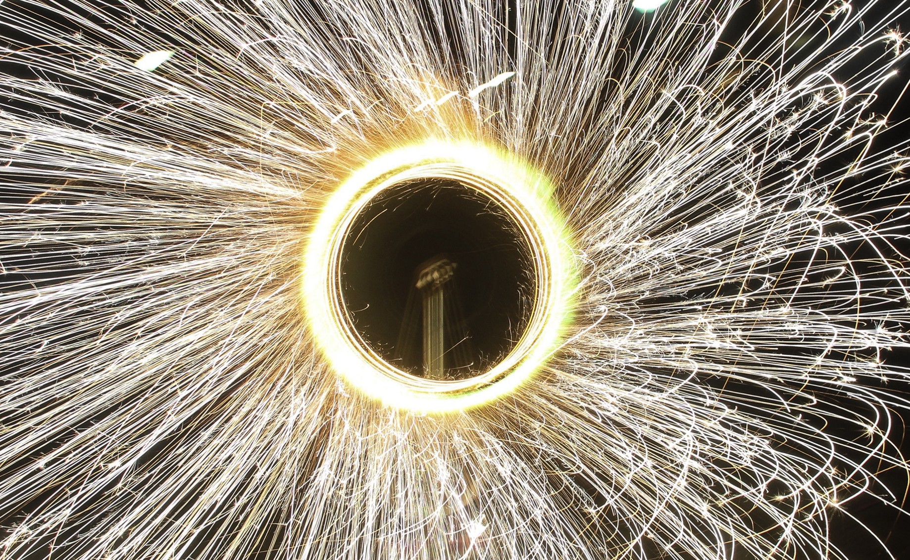 closeup photo of a lit catherine wheel firework spinning to create a circle of sparks