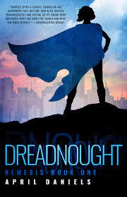 The image shows the cover of April Daniels' novels 'Dreadnought'. Dreadnought show a feminine silhouetted in black standing on a black hillside. She is wearing a blue flowing cape that is blowing sideways to the left, and is looking towards a city skyline that is rendered in pastel pinks and greys. Above the city is a blue sky.