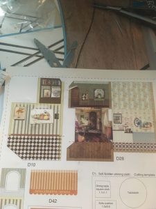 Page of paper cutouts of the insides of the houses with the posters replaced by the modified versions.