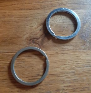 Two keychain rings on a wooden table.