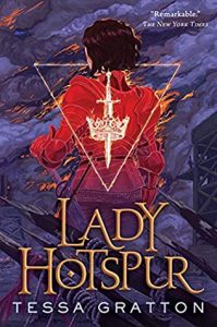 The image shows the cover of Tessa Gratton's 'Lady Hotspur'. The background of the image is a grey purple smoke filled sky. In the centre of the image a figure stands, back toward us, in red armour, orange flames edge it in places. Overlaying this is an inverted triangle in the centre of whitch is a sword through the centre of an ornate crown. These are all in white flame. The title 'Lady Hotspur' is in golden lettering along the bottom of the cover, behind witch sharpened pikes point towards the figure.