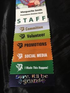 Marguerite's Staff Badge from Dublin Worldcon in 2019 featuring a series of ribbons showing her many roles and active involvement.