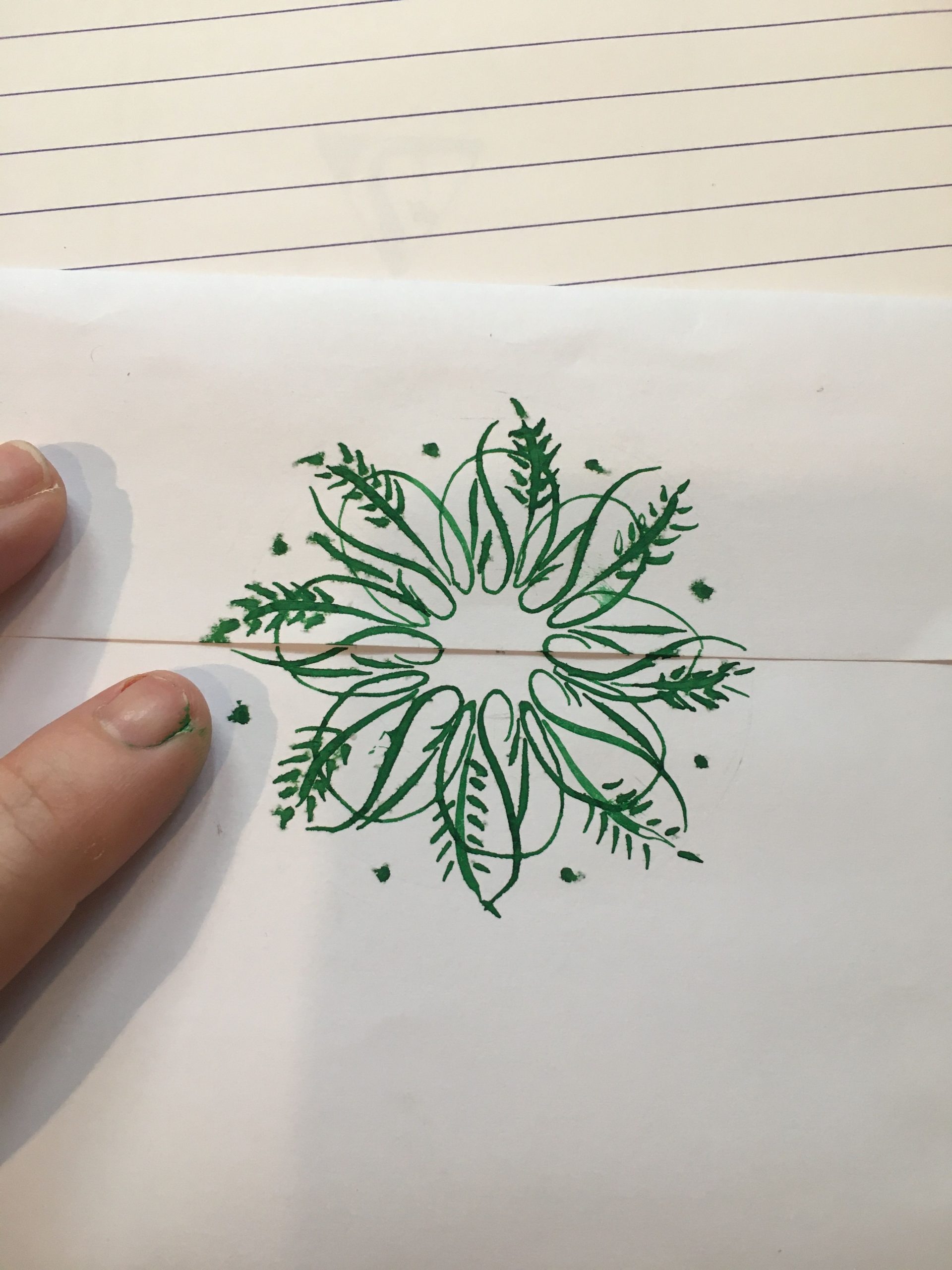 a sealed envelope decorated with a flowery green flourish over the sealed edge