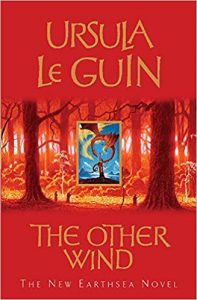 The image shows the cover of Ursula Le Guin's novel 'The Other Wind'. The cover has a red colour palate. In the centre third of the cover there is a sparse forrest scence of the trunks of trees rendered in gold and brown. In the very centre of that - positioned between two tree trunks - is a regtanfular frame of a blue sky, a mountain tower and a red dragon. 