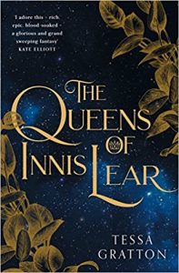 The image shows the cover of Tessa Gratton's 'Queens of Innis Lear'. The title is in the centre of the cover in gold writing. Golden brzone leaves trail up the bottom left and top right of the cover. The background is a dark blue star filled sky.