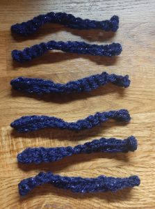 Six strips of navy-coloured crochet to be used as ties.