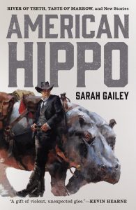 Cover of American Hippo featuring a person standing in front of a hippo on a light background with gray writing