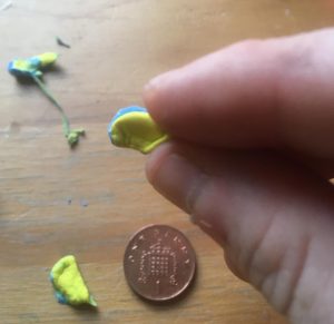 An ear being formed out of one half of the blue/yellow sheet.