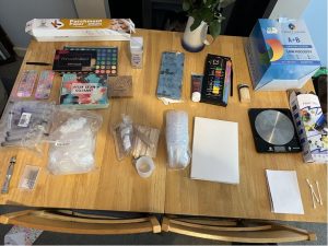 aerial shot of all necessary materials for craftig resin dice on a wooden dining table