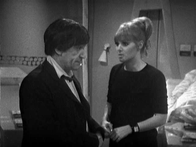 “Polly (Anneke Wills) looks unconvinced as she stands next to The Doctor (Patrick Troughton).”