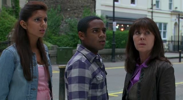 “Rani (Anjli Mohindra), Clyde (Daniel Anthony), and Sarah Jane Smith (Elisabeth Sladen) are on a street, captivated by an unseen object, engrossed in their observation.”